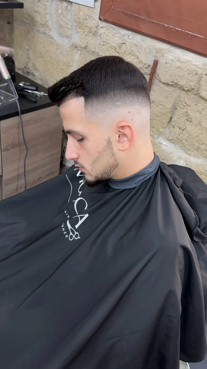 Skin fade coordinato con barba corta definita